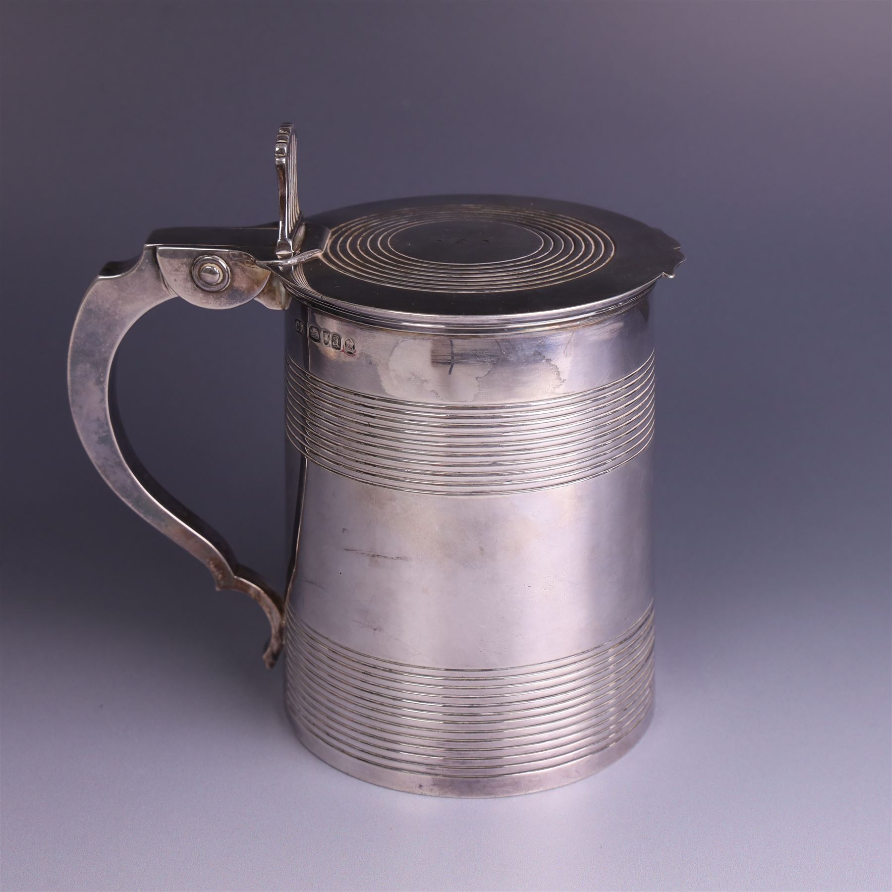 George III silver lidded tankard, with two ribbed bands to the cylindrical body, the hinged lid with concentric circle to cover and pierced thumbpiece, hallmarked Charles Fox I, London 1816, including thumb piece H16cm