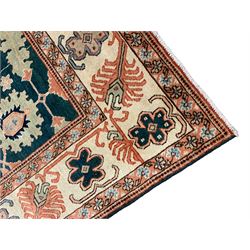 Persian emerald green ground rug, the field decorated with large stylised plant motifs, ivory ground border with repeating leaf motifs, the guards decorated with trailing branch and flowerhead motifs