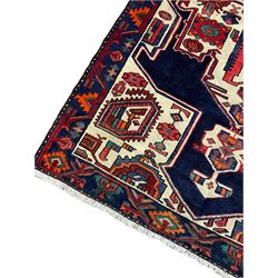 North West Persian Heriz rug, blue and ivory ground, decorated with stylised plant motifs, the border decorated with repeating geometric design 