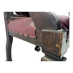 Late Victorian Gothic-revival armchair, arched crest rail carved with tracery and trefoil detail, padded circular back and seat, brass studded burgundy leather upholstery, shaped armrests with scrolled terminals, on square tapering supports