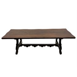 Large Spanish hardwood dining table, on shaped open ends supports joined by stretcher 
