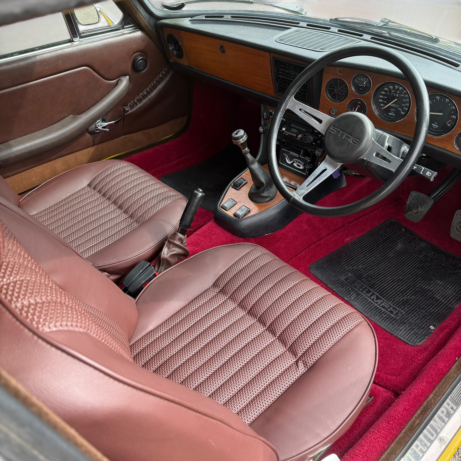 1973 Triumph Stag Mk II 3.0 V8 Manual with Overdrive

Registration: FTV 859L
Date of first registration: 8th March 1973
Recorded mileage: approximately 50,000 miles
Engine: 2,997cc petrol V8
Transmission: four-speed manual with overdrive

An attractive manual-overdrive example of Triumph’s celebrated V8 grand tourer, finished in yellow and supplied with both a removable hardtop and folding soft top.

The car has been the subject of extensive restoration and mechanical work, supported by a large history file containing invoices, notes and photographs documenting the work undertaken. The accompanying records indicate that the engine was rebuilt at approximately 36,000 miles, including re-boring of the block, checking and machining of the top faces, and steam cleaning following machining.

Further work and replacement parts are understood to include an upgraded radiator, electric cooling fan, Stag Webber header tank kit, complete set of cooling hoses and clips, fuel pump and filters, alternator, distributor cap, HT leads, spark plugs, front brake calipers and hoses, rear brake cylinders, tyres, front lights and LED bulbs. Various seals, interior trim items and seat components have also reportedly been renewed.

The car is believed to have been dry-stored from 1994 until 2017, with a substantial programme of recommissioning and improvement subsequently undertaken between 2017 and 2023. The history file also includes earlier MOT certificates dating from 1988 to 1994.

Offered with its V5C, hardtop, soft top, extensive restoration and maintenance history, photographic record and a quantity of useful spare parts, including a new dashboard veneer set.