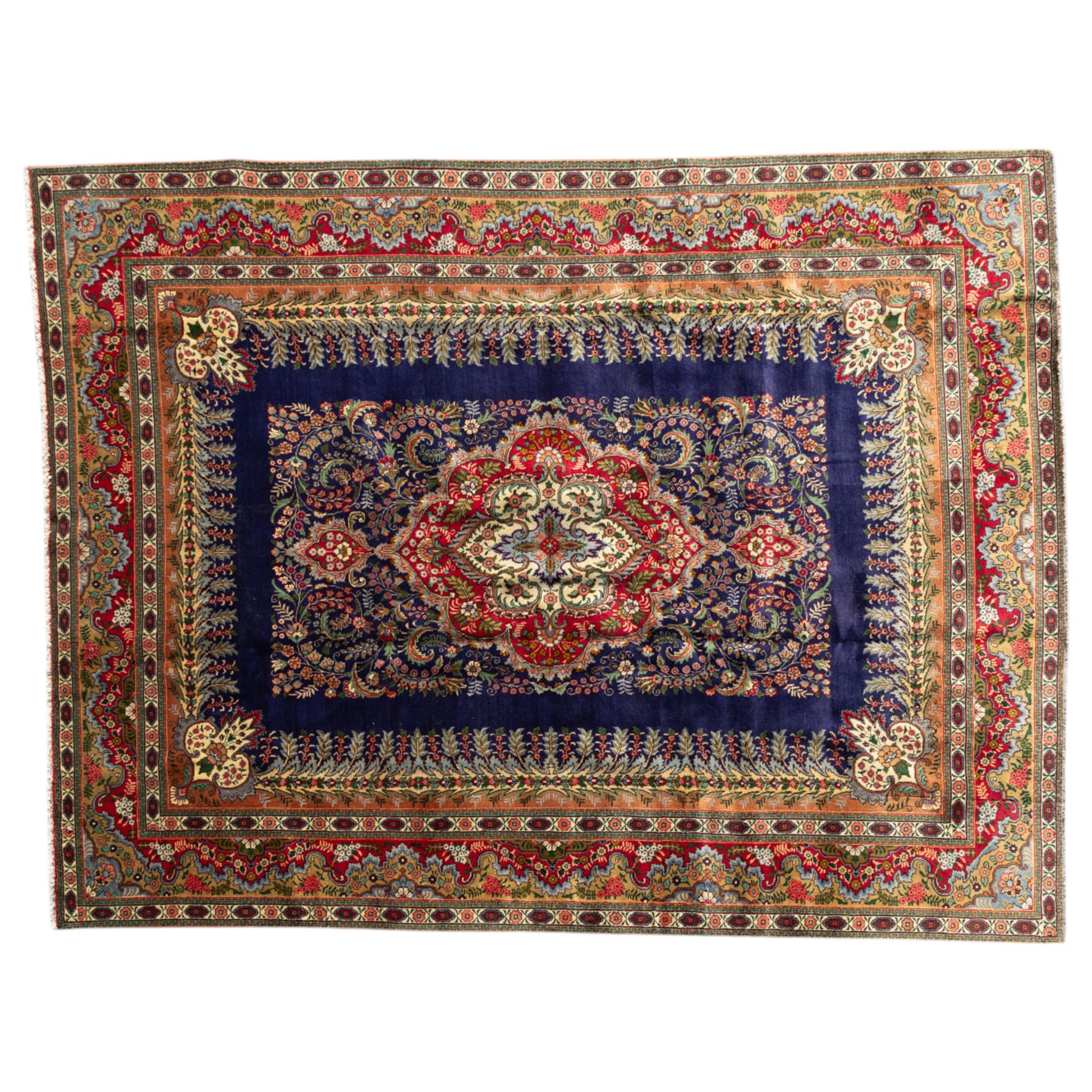 Persian Kashan rug, deep blue ground with central red and ivory lobed medallion framed by dense floral motifs, multiple borders with foliate and geometric design in red, blue and ivory, from the central Iran region
