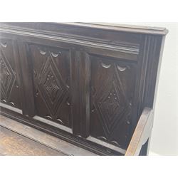 17th century and later box settle, the quadruple panelled back carved with lozenges above hinged seat, panelled front with scroll carved cresting rail and guilloche carved uprights, moulded stile supports joined by arcade carved rail 
