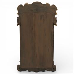 In the manner of Thomas Johnson - circa 1900 Georgian Revival giltwood wall mirror, the shaped rectangular plate within a foliate and scallop carved slip and richly ornamented frame, surmounted by a pierced cartouche crest centred with a protruding relief carved winged cherub mask and issuing scrolling acanthus and floral ornament, the sides with eagle masks over acanthus scrolls, terminating in a shaped apron with moulded rosette and spiralling acanthus leaves