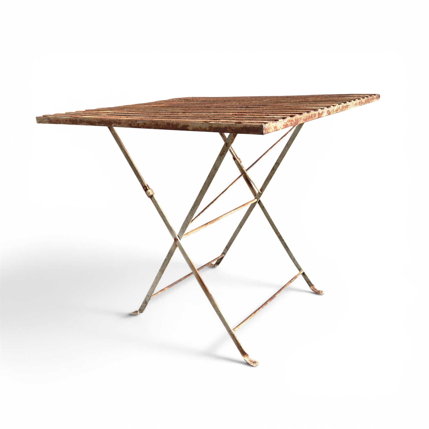 Pair of French 1920's wrought metal folding bistro café tables, the strapwork top over a folding X-frame base, in rustic white painted finish