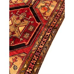 Persian Karajeh red ground runner, the field set with three trailing geometric medallions, decorated all over with stylised plant motifs, geometric design triple band border