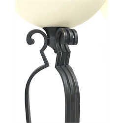 Pair of black painted metal floor standing uplighter lamps, each of skeletal form with three clusters of scrolling tubular supports on circular base with upturned semi-circular mottled glass shade H182cm