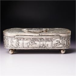 19th century continental silver box of oval design , the hinged cover with swing handle embossed with sailing ships, castle etc, the base decorated with horse and cart in rural landscape and the sides with a hunting scene on ball feet L15cm