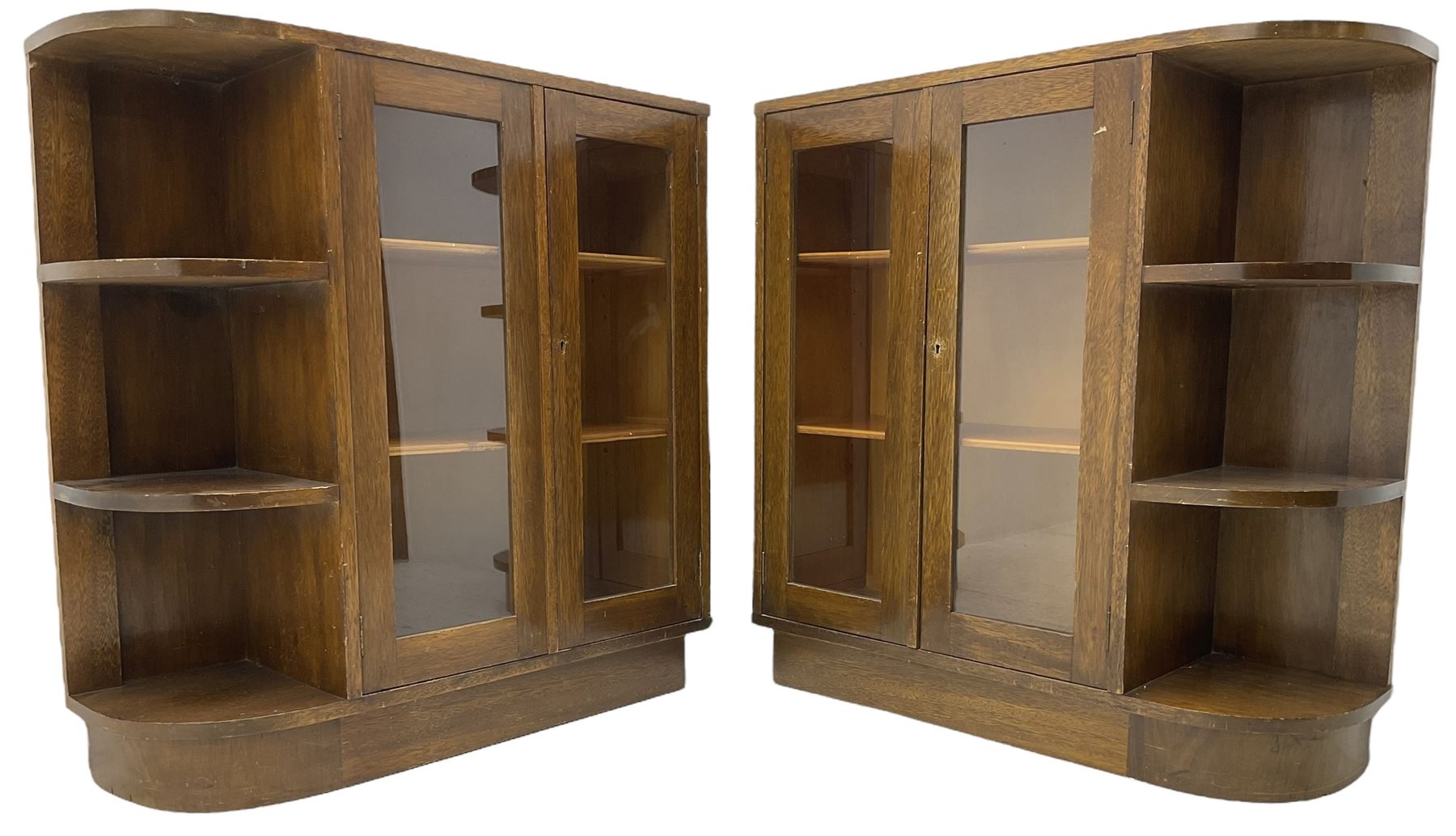 Pair of mid-20th century oak bookcases, rectangular form with curved ends, enclosed by glazed doors and fitted with shelves