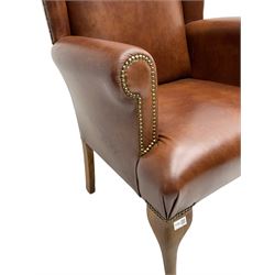 Beech framed wingback armchair, upholstered in brown fabric with stud work, on cabriole front supports