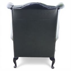 Late 20th century green leather chesterfield style wingback armchair, with deep buttoned back, scrolled wings and arms with studded borders, loose seat cushion, raised on cabriole legs