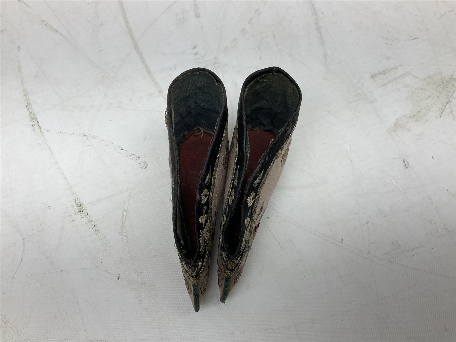 French silver plated wine taster of typical form, stamped, together with a silver plated napkin ring, and an 'Alpaca Silver' pill box with mother of pearl detailed cover, (3) together with Two pairs of late 19th/early 20th century Chinese Lotus shoes for binding feet, the first with purple silk heavily embroidered with ornate floral motifs, L10cm the second larger fuschia and black pair with thicker sole embroidered with flowers, L14cm