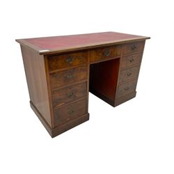 Late 19th to early 20th century walnut pedestal desk, rectangular top inset with red tooled leather writing surface, over a central frieze drawer flanked by two pedestals, each fitted with four graduated drawers with brass escutcheons and drop handles, the whole raised on a plinth base