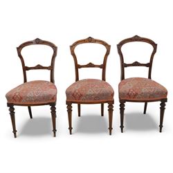 Set of six late Victorian mahogany dining chairs, the shaped top rails carved with anthemion motifs, above pierced splats, floral and geometric fabric seat, on turned and fluted front legs