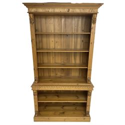 Polished pine and elm bookcase, projecting moulded cornice over three shelves and fluted uprights, leaf and S-scroll carved brackets, the lower section with gadroon moulded top fitted with single shelf, matching fluted uprights and brackets, on plinth base 