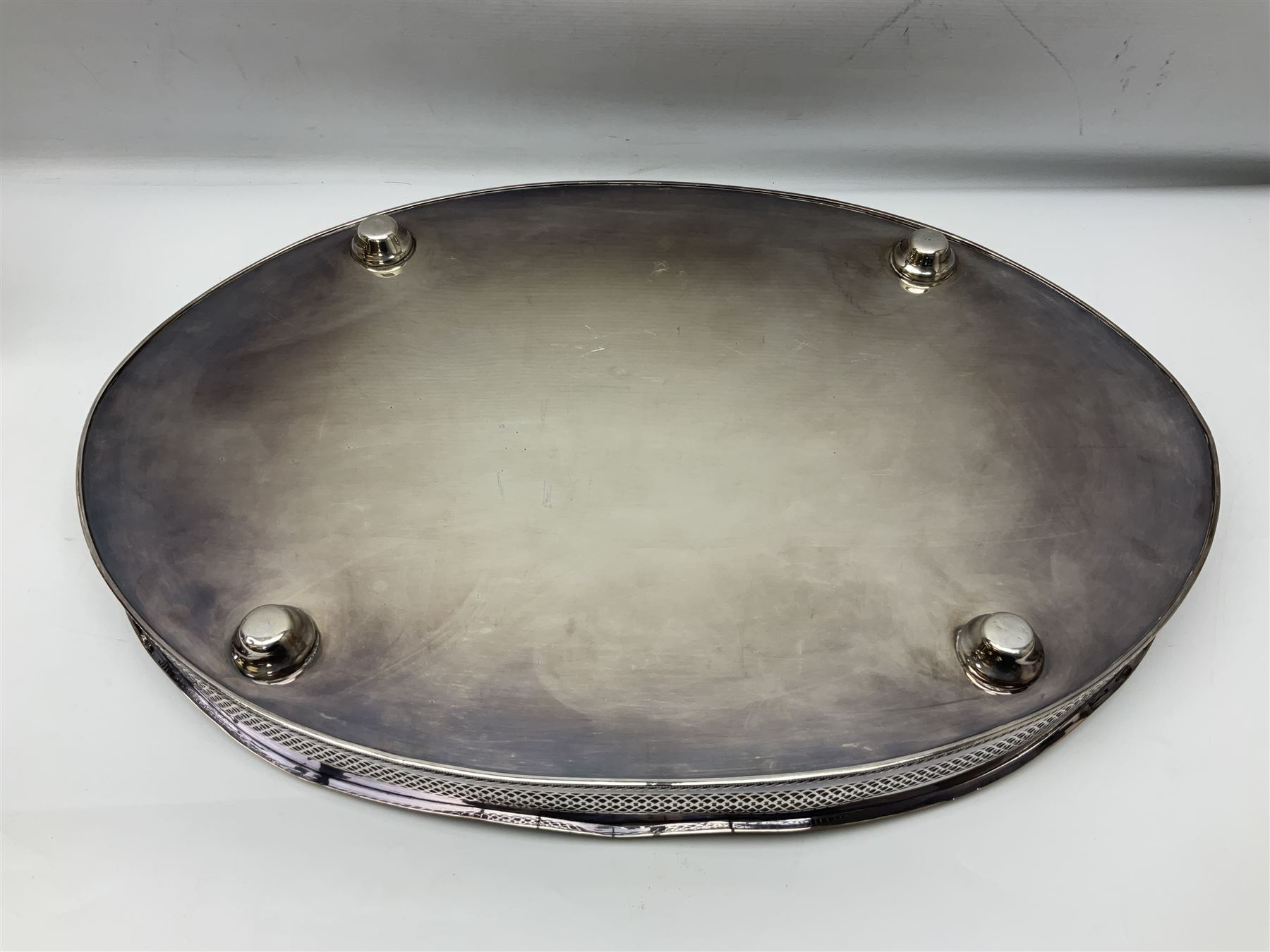 Pair of Mappin and Webb silver plate pierced pedestal bon bon dishes, together with other silver plate comprising teapot stand engraved with lion's head to centre, two cut glass claret jugs, two bottle coasters with acorn decoration, two open salts upon dolphin mounts, tea caddy, three piece cruet set and a large oval tray with pierced sides and upon four ball feet