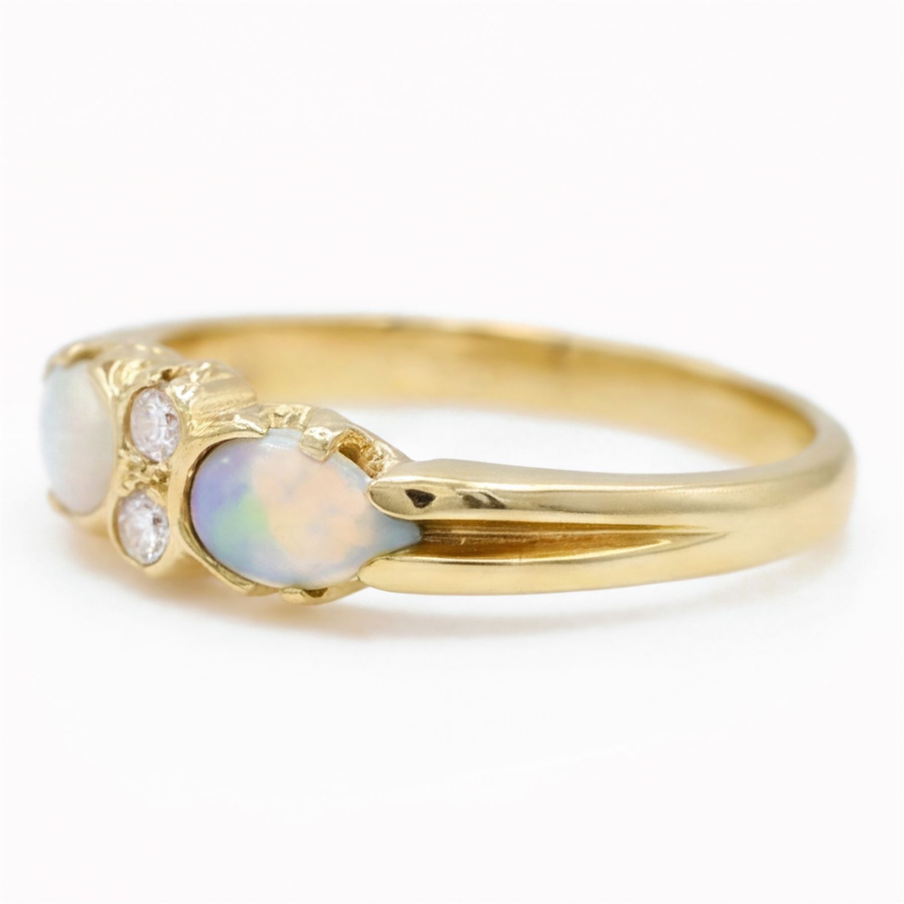 18ct gold opal and diamond four stone ring, two round brilliant cut diamonds, with a single cabochon pear cut opal set either side, London 1994