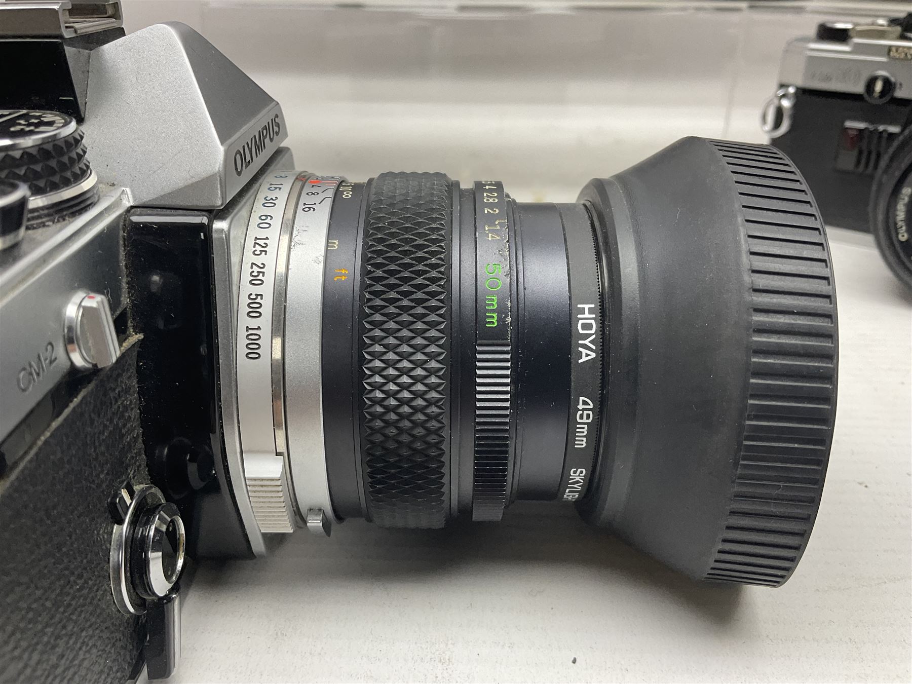 Four Olympus camera bodies, including Olympus OM10, serial no 20744269, with 'Olympus OM-System Zuiko Auto-S 50mm 1:1.8' lens serial no 3633644, Olympus OM-2 camera body serial no 460280 with 'Olympus OM-System G.Zuiko Auto-s 1:1.4 f=50mm' lens, serial no 729750, etc 