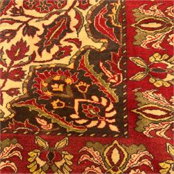 Persian Kerman hand-knotted rug, ivory and crimson ground, central medallion surrounded  by a floral foliate pattern, main border with repeating design of floral cartouches and palmettes, and narrow vine work guard border  