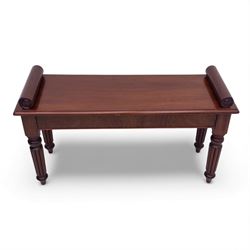 Regency style mahogany window seat, in the manner of George Bullock, with rectangular top with twin scroll ends, raised on four turned and reeded supports terminating in bun feet