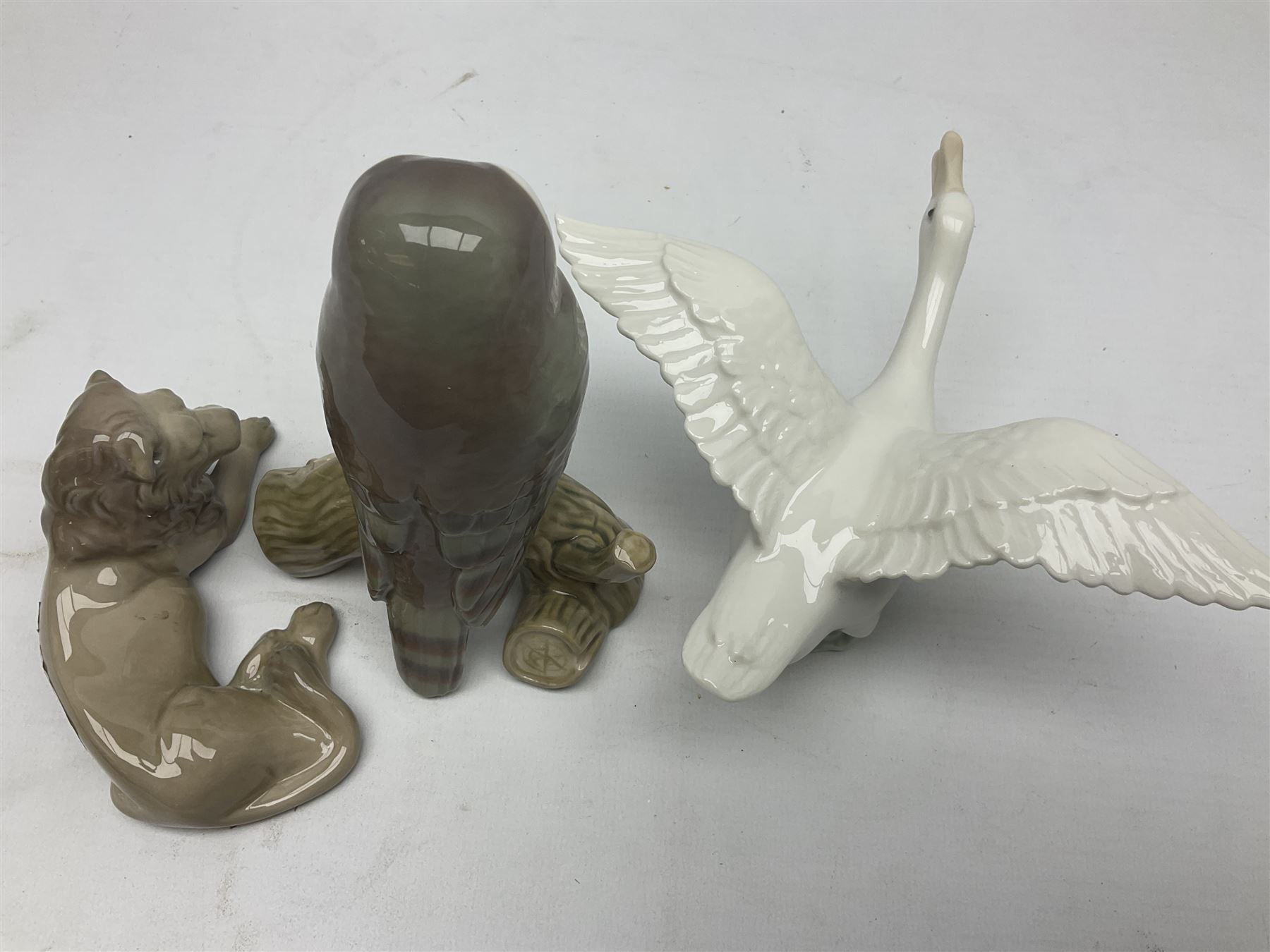 Lladro figures of animals, comprising Mini Lion no 5436, Beautiful Burro no 5683, Hawk Owl no 5422, Beagle Puppy Sitting no 1071, Duck Flying no 1264, Miniature Cat no 5308 and Small Papillon Dog no 4749, four with original boxes, largest example H14cm