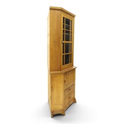 Acorn Industries - oak floor-standing corner cabinet, the top fitted with astragal glazed door enclosing four shaped shelves, the base with single panelled cupboard over two drawers, raised on four stepped feet, carved with acorn signature to top and base, by Alan Grainger, Brandsby