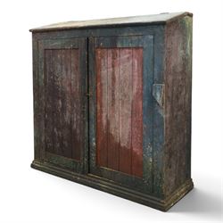 19th century painted and lacquered pine clerks desk bureau on cupboard, hinged fall-front enclosing three compartments, over slatted panelled doors enclosing two perforated shelves, on skirted base, in rustic forest green and red finish