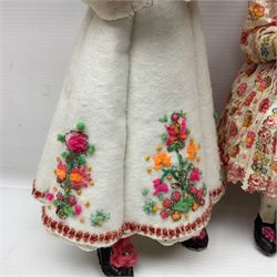 Anna Meszaros Hungary - three hand made needlewrok figurines - each wearing a lon floral dress and bonnet and holding a bouquet of flowers, tallest H32cm (3)  Auctioneer's Note: Anna Meszaros came to England from her native Hungary in 1959 to marry an English businessman she met while demonstrating her art at the 1958 Brussels Exhibition. Shortly before she left for England she was awarded the title of Folk Artist Master by the Hungarian Government. Anna was a gifted painter of mainly portraits and sculptress before starting to make her figurines which are completely hand made and unique, each with a character and expression of its own. The hands, feet and face are sculptured by layering the material and pulling the features into place with needle and thread. She died in Hull in 1998.