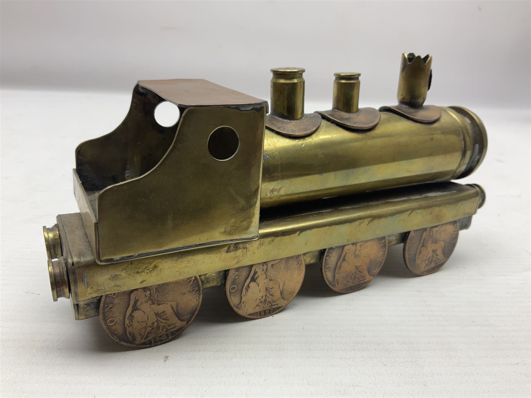 Trench Art - WWI 0-8-0 steam locomotive made from brass, copper and late Victorian pennies and half-pennies L17.5cm; WWI brass and copper tank candleholder; WWI brass shell case two-handled vase inscribed 'RFA France 1914-17'; and an unrelated brass plant holder (4)