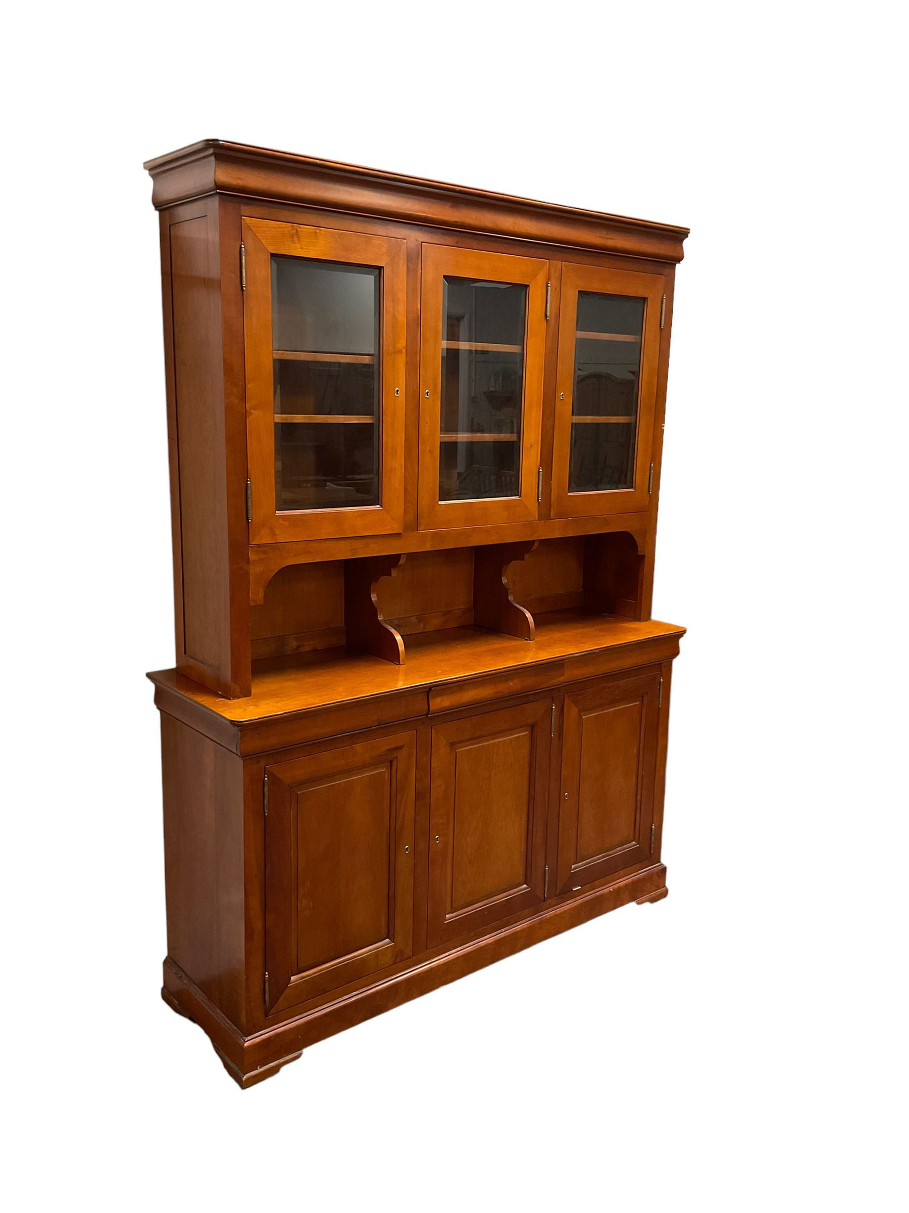 Multi-York -  Loire cherry wood dresser, shaped cornice over three glazed doors enclosing six shelves, the lower section fitted with three shallow drawers with shaped fronts over three cupboards with panelled doors, raised on plinth base with bracket feet