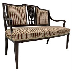 Edwardian mahogany framed three-piece salon suite - two-seat sofa, stepped cresting rail over acanthus and scroll carved pierced splat, upholstered in striped fabric (W124cm, H87cm, D62cm); and a pair of matching armchairs (W60cm) 