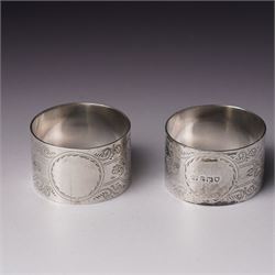 Pair of engraved silver napkin rings London 1912, two 19th century fiddle pattern dessert spoons, four condiment and teaspoons and a silver pepperette