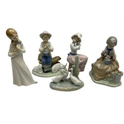 Group of Nao figures to include Friends and Flowers, boy sitting on a log playing the flute with two sheep by his feet, geese figure group, and two figures of girls holding puppies, all with marks beneath, tallest H19cm