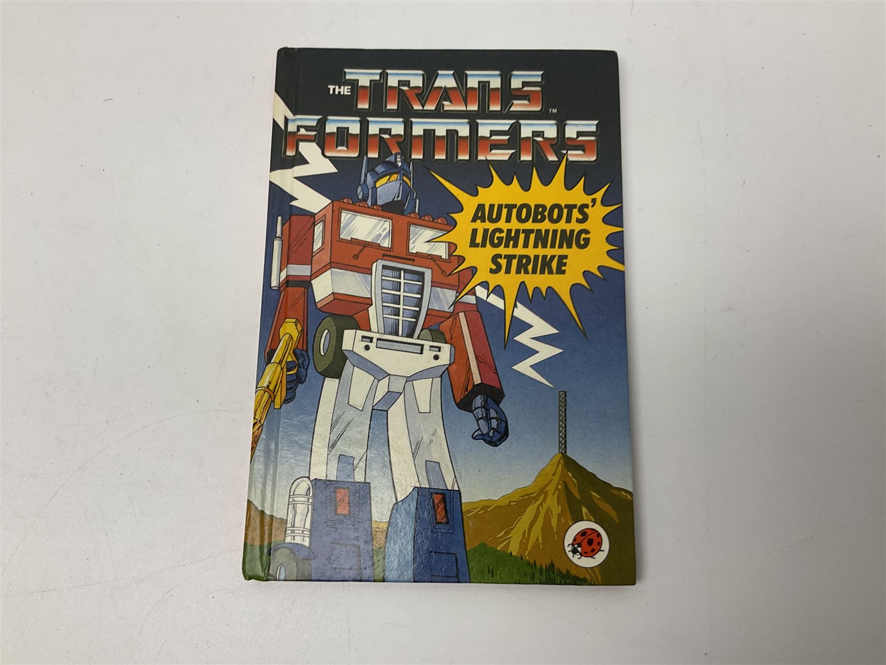 Four 1980sTransformer G1 - Optimus Prime 1984; DinoBot Sludge (Diplodocus) 1984; Cyclonus 1986; and Runamuck 1986; with paperwork; seven Bandai Robo Machines Robots/Transformers; almost fully stocked Panini Sticker album; two annuals; three comics; two posters; and Ladybird story book