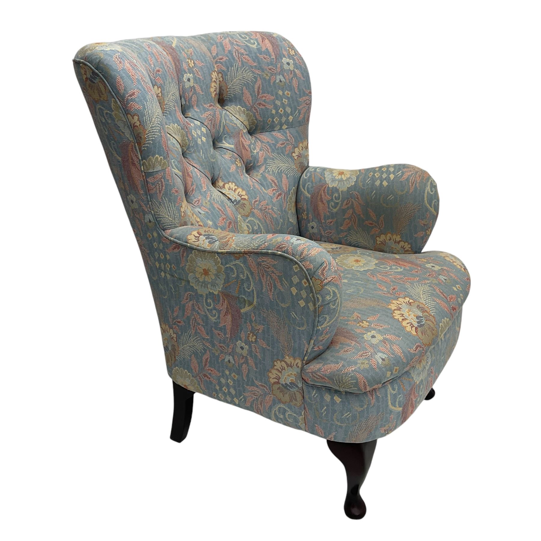 Mid-20th century wingback armchair, upholstered in soft blue floral patterned fabric with button-tufted backrest and curved arms and raised on cabriole supports