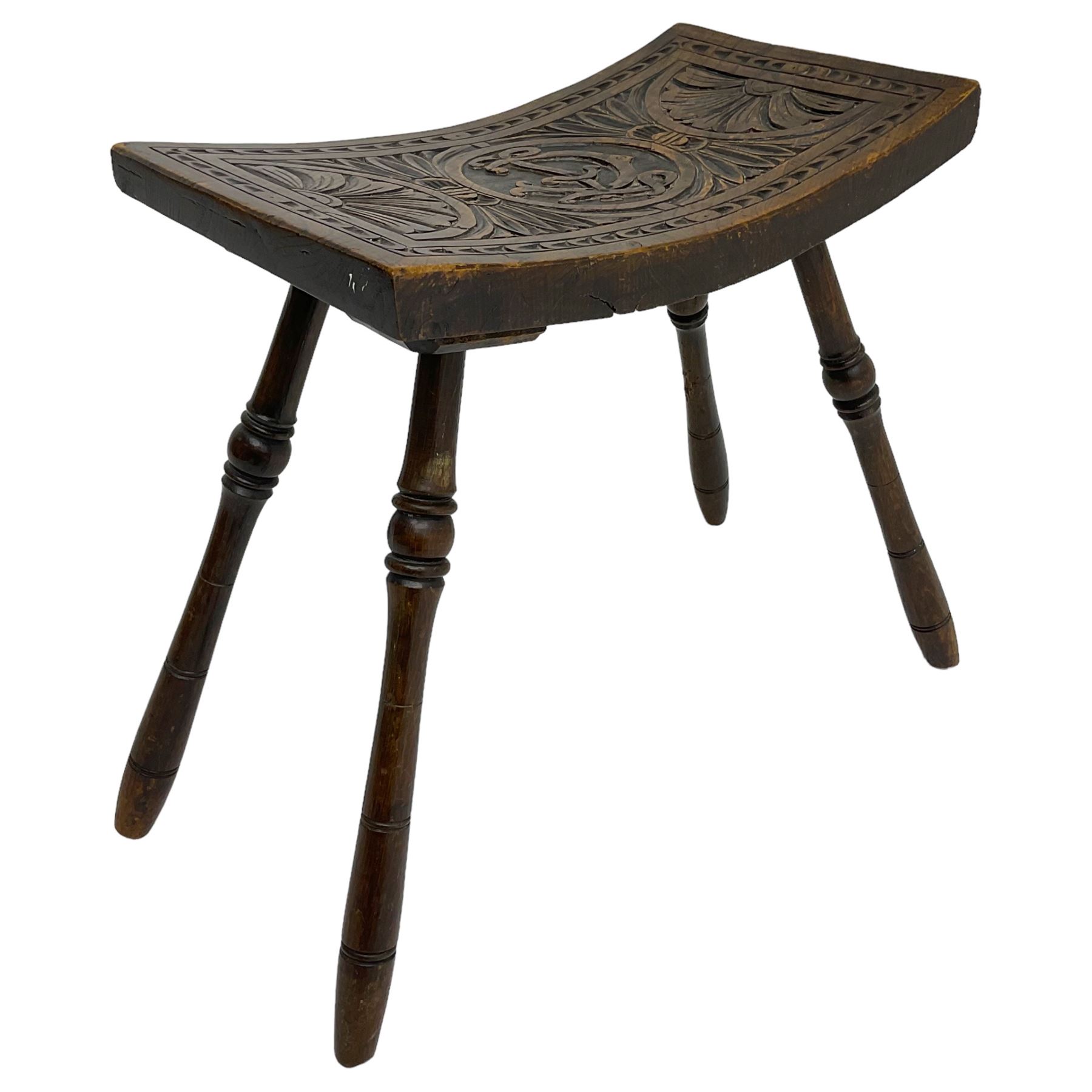 Late 19th century oak stool, rectangular dished top relief carved with floral lunettes and central insignia, on turned splayed supports