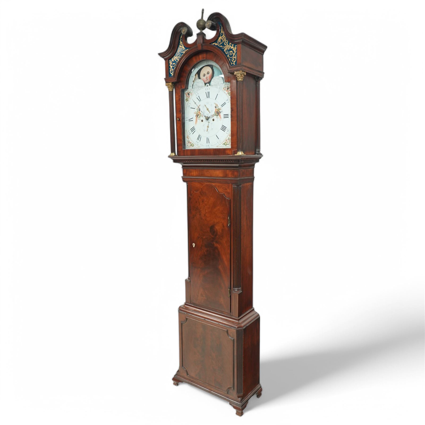 Henry Fisher of Preston (Lancs)- a fine late 18th century Mahogany 8-day longcase clock c 1790, with a swan necked pediment, brass paterie and Verre Eglomise glass panels with a blue ground beneath, broken arch hood door flanked by reeded pilasters with brass Corinthian capitals, trunk with inset reeded quarter columns and a wavy topped door in figured mahogany, plinth with conforming canted corners, raised panel and bracket feet, with an early Wilson painted dial comprising a colourful depiction of birds of paradise to the centre and a working lunar disc to the arch, with painted floral spandrels within gesso borders and matching steel hands, Roman numerals, five-minute Arabic's, minute markers and matching seconds and date dials, dial pinned via a cast Wilson falseplate to a rack striking four-pillar movement, striking the hours on a bell. With weights and pendulum.
Henry Fisher is recorded as working in Preston, c1742-95.
 