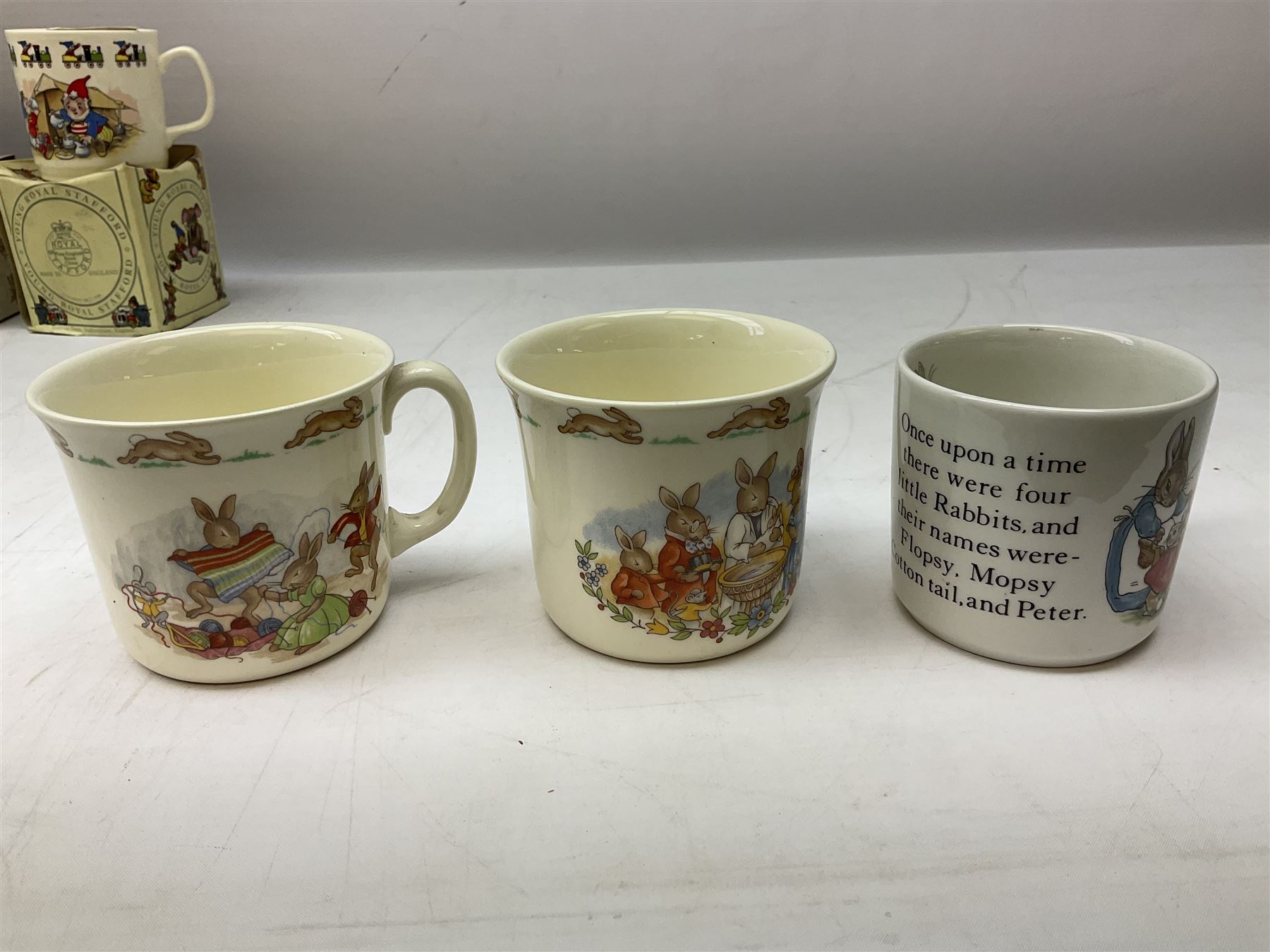 Royal Doulton Bunnykins nursery set in box and two cups, together with two Wedgwood Peter Rabbit mugs and Royal Staffordshire Noddy money box and cup (7)