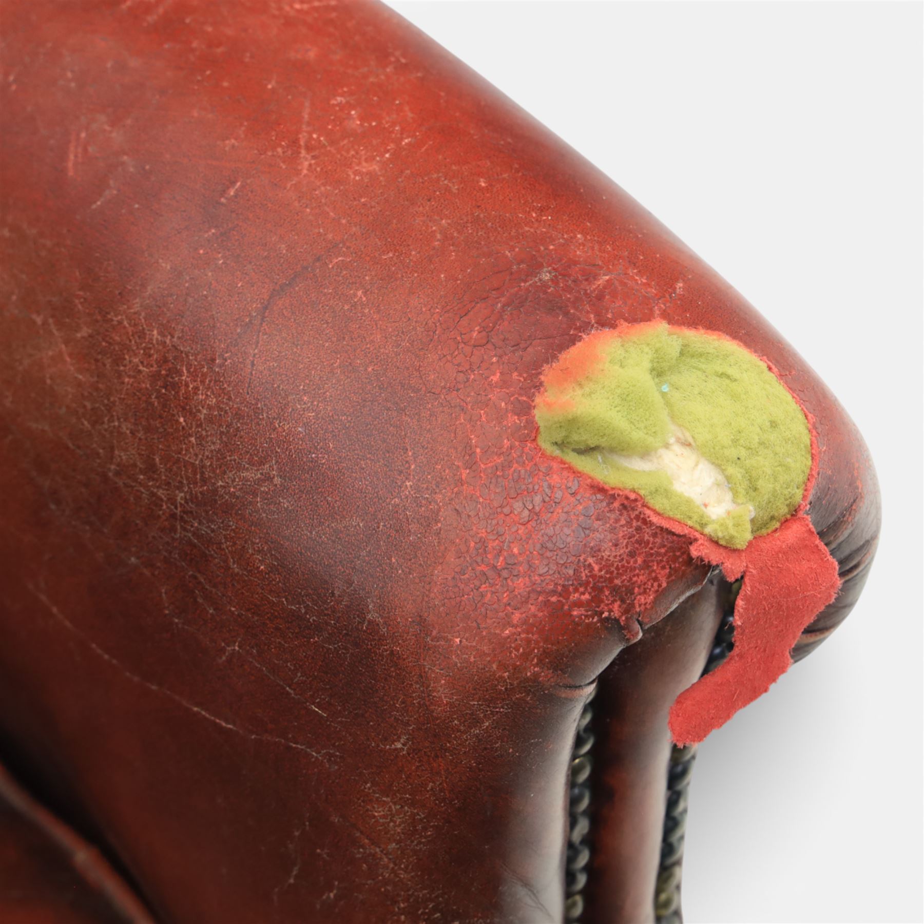 Georgian design wingback armchair upholstered in oxblood leather, the deep button upholstered back with shaped wings and out-scrolled arms, close nailhead trim to the edges, over a loose seat cushion, raised on cabriole front supports terminating in claw and ball feet