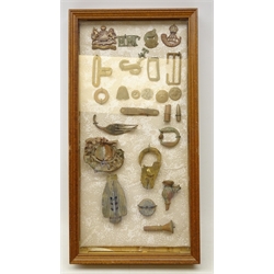  WWI & II battlefield metal detecting finds, discovered around Northern France including Durham Light Infantry sweetheart brooch,  Manchester Regiment cap badge, locks, coins, pen knife, artillery shell and other finds in glazed display case, H47cm x W24cm   