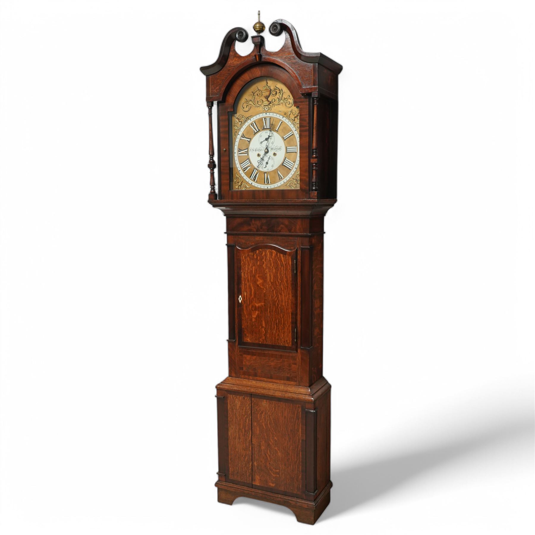 John Henry Coates of Wakefield- late19th century oak and mahogany 8-day longcase clock c 1860, with a swan necked pediment and central brass ball and spire finial, break arch hood door flanked by unusual turned pilasters, trunk with recessed rectangular corners and a wavy topped door, on a square plinth with conforming recessed corners and raised on a shaped base, fully painted dial with matching decorative rococo painted decoration to the spandrels and arch, with 