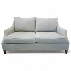 Neptune traditional style two-seat sofa, sloped back rest, gently flared arms, studded upholstered in a light grey fabric on square tapered legs 