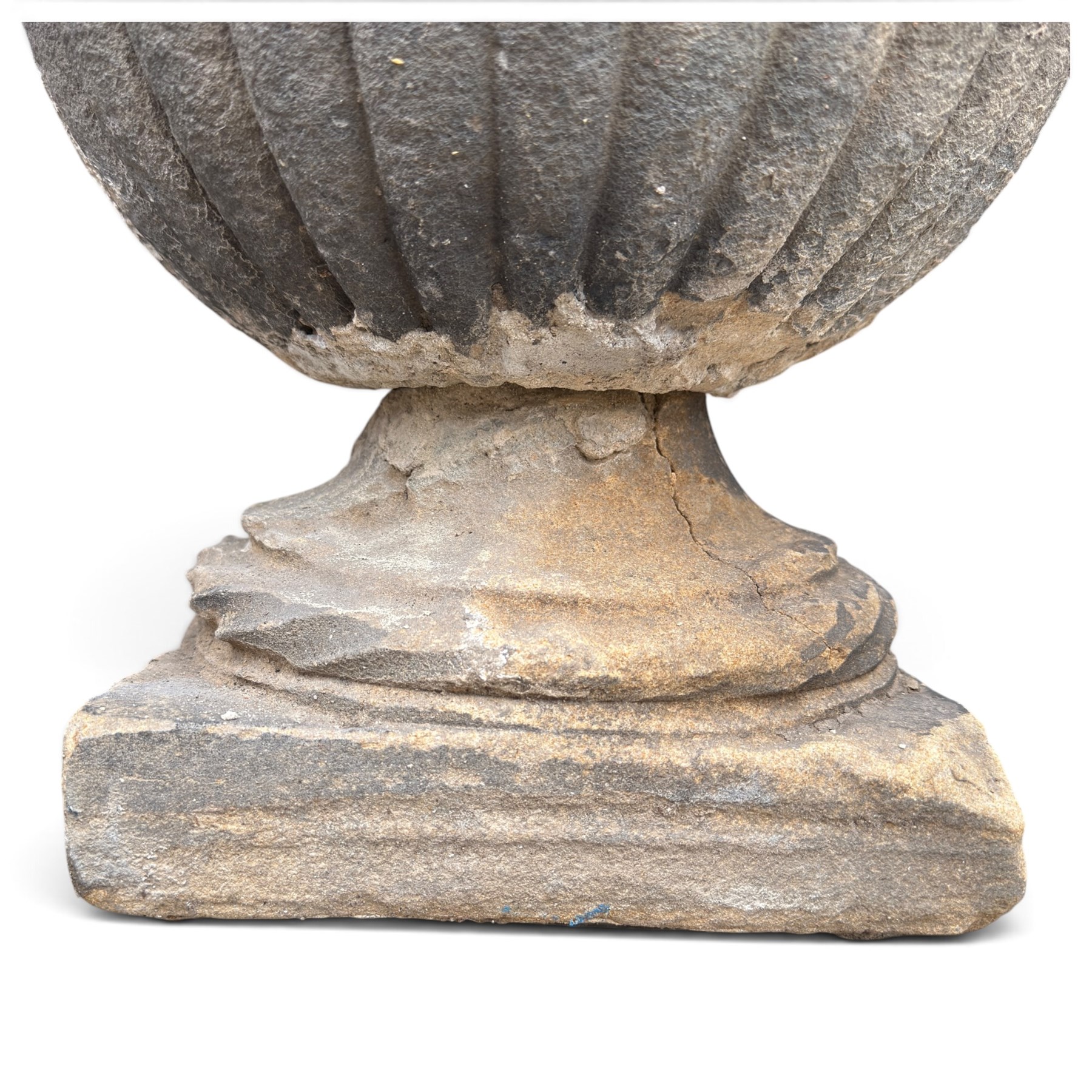 Set of three 19th century weathered carved sandstone garden urns of Neoclassical campana form, the broad everted rim carved with pointed egg-and-dart motifs, above a plain waisted bowl with gadrooned underbelly, on moulded rope-twist socle and square plinth base
