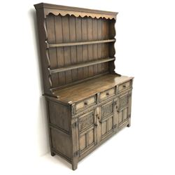 Jacobean style oak dresser, raised two tier plate rack with projecting cornice above three drawers above three cupboards, stile supports