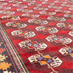 Tekke Bohara hand-knotted rug, madder red field decorated with an all-over design of repeating octagonal guls and latch-hook motifs within multiple geometric borders and cotton fringe ends 