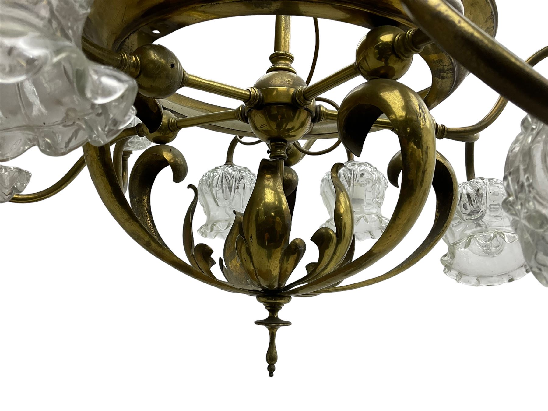 Mid-20th century brass lightolier or light fitting, the scrolling foliate branches connected with a central ring, terminating in ten tulip shaped cut glass sades, pointed terminal beneath