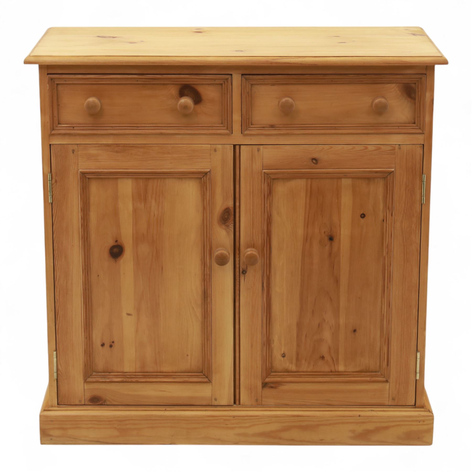 Contemporary pine storage cabinet, the rectangular top with rounded corners, over twin drawers and panelled cupboard doors, fitted with turned knob handles, plinth base