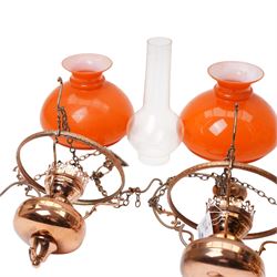 Pair of brass pendant light fittings with orange glass shades and another with partly frosted glass shade 