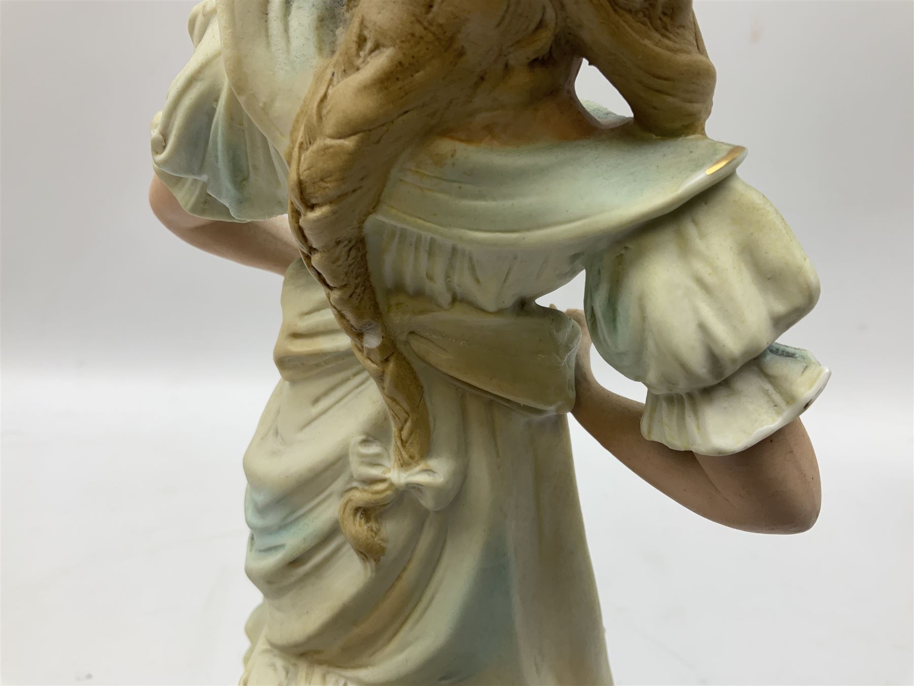 Late 19th century continental spill vase as a young girl standing beside an open tree trunk H21cm; and three German bisque figures (4)